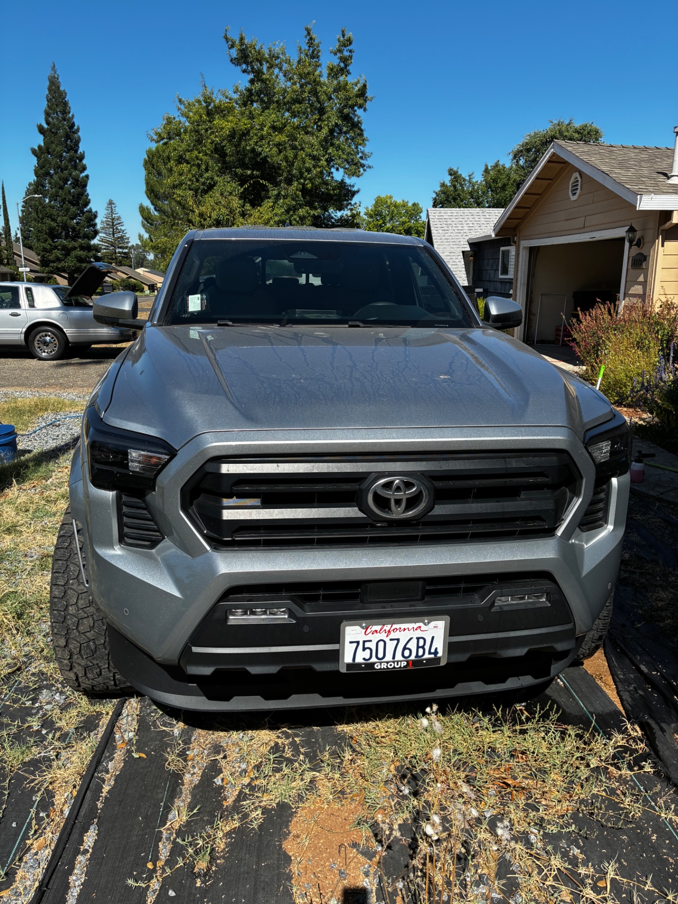Freshly detailed silver 2024 Toyota Tacoma front view with glossy hood and clean grille after Detail X full detail in Sacramento County