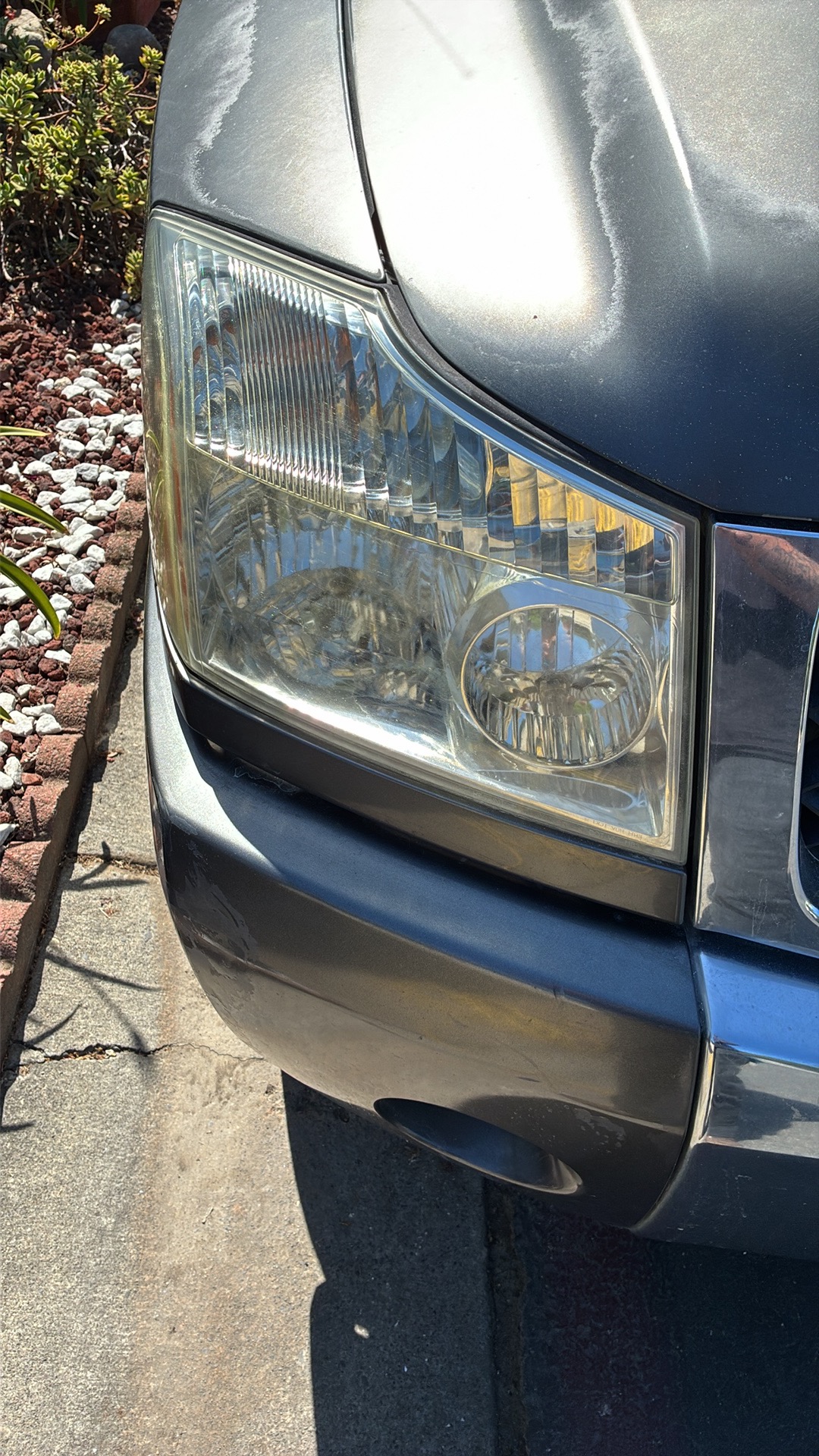 Yellowed hazy headlight lens on a Dodge Ram before Detail X headlight restoration